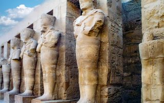 Tempel von Karnak - Hinter dem Eingang öffnet sich ein Hof - umgeben von kolossalen Königsstatuen